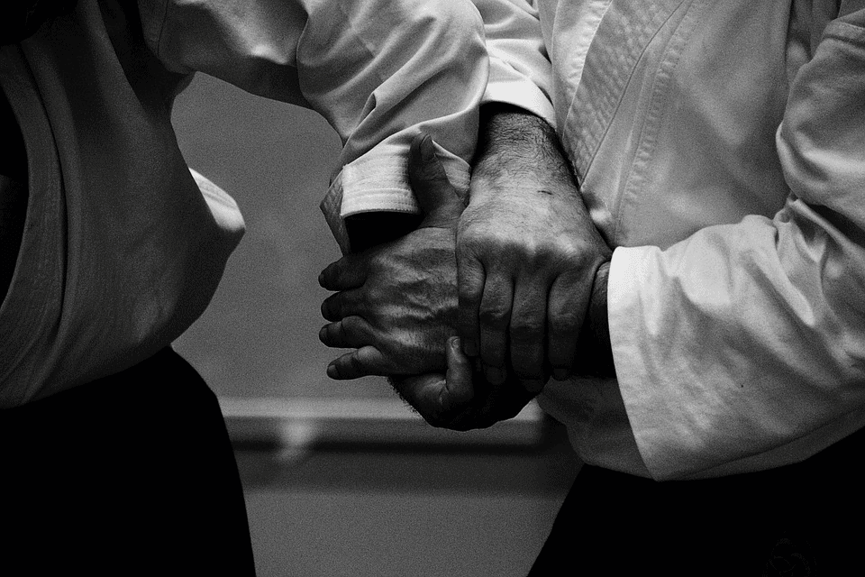 Two aikidokas engaged in hand lock | Fighting Arts Health Lab