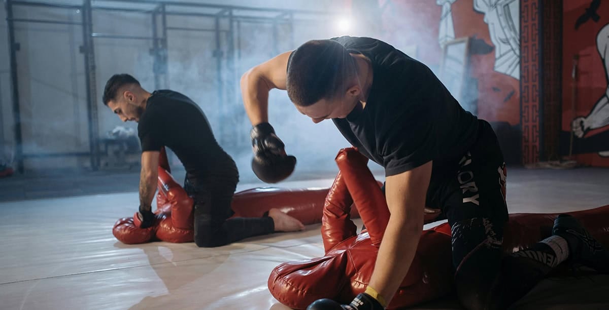 Combat athletes practicing top control with ground and pound